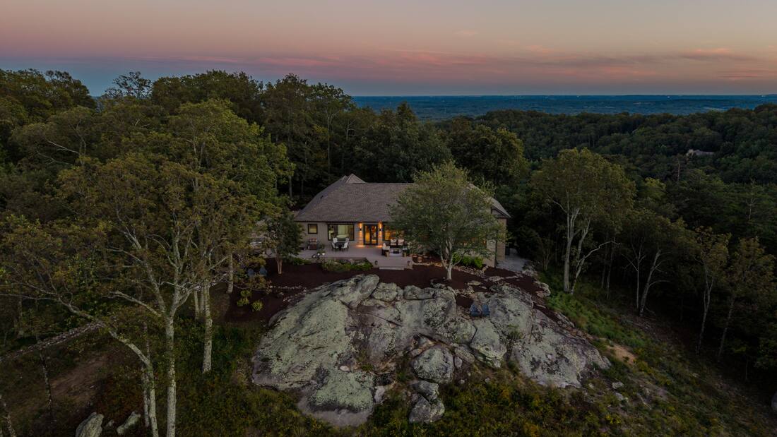 The house on its outcrop at dusk